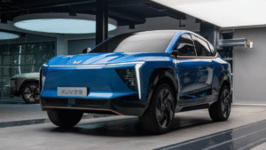 Mahindra Electric SUV XUV e9 in blue with aerodynamic design and LED DRLs displayed indoors